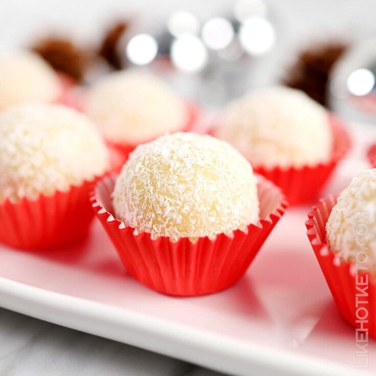 Decadent coconut white chocolate truffles in pink cupcake liners, perfect for Valentine's Day or special occasions, featuring coconut flakes coating a creamy white chocolate interior.