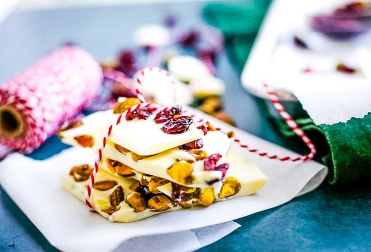 Rich white chocolate bark with dried cranberries, pistachios, and a red-and-white striped twine, perfect for holiday gifting or festive celebrations.