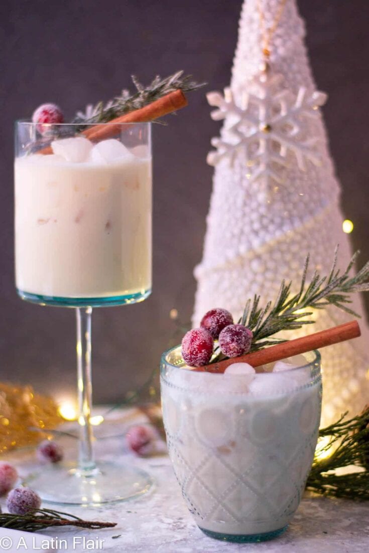 Festive holiday milk cocktails garnished with cinnamon sticks, cranberries, and sprigs of pine, perfect for Christmas celebrations or winter gatherings.