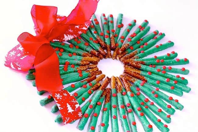 Festive holiday wreath made from DIY candy cane and pretzel decorations, adorned with a red ribbon for Christmas decor, perfect for adding a joyful touch to seasonal celebrations.