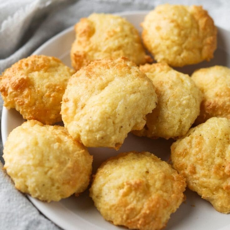 Crispy homemade chicken nuggets on a white plate with a rustic cloth background, perfect for comfort food, family meals, and snack ideas.