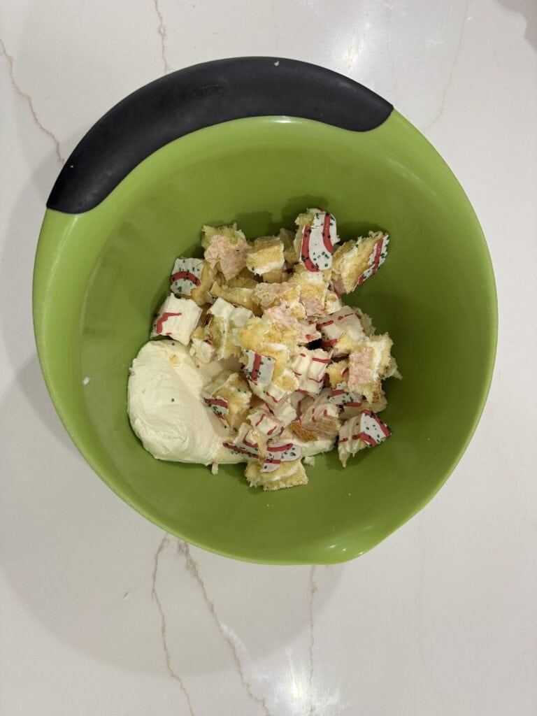 Shredded Christmas-themed candy canes on vanilla ice cream in a green bowl, festive holiday dessert, colorful seasonal treat, peppermint candies for Christmas, enjoyable winter holiday sweets.