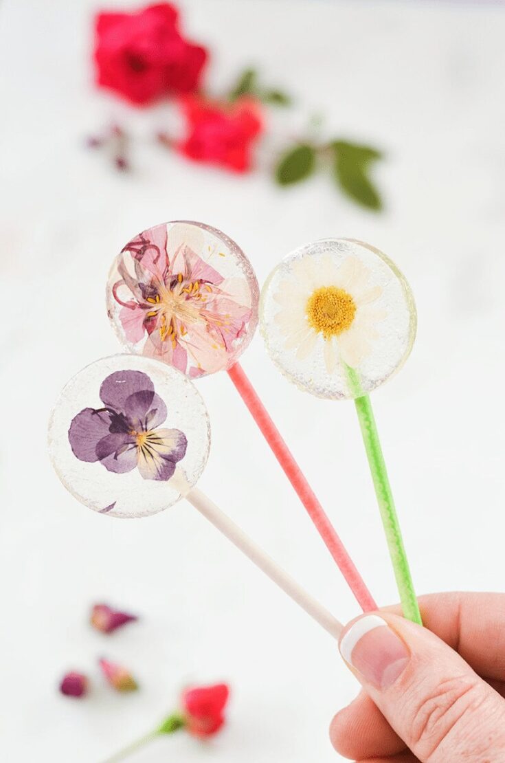 Colorful floral pressed flower lollipops with edible flower designs, perfect for spring or wedding favors. Handmade, decorative, and unique edible treats from A Hundred Affections.