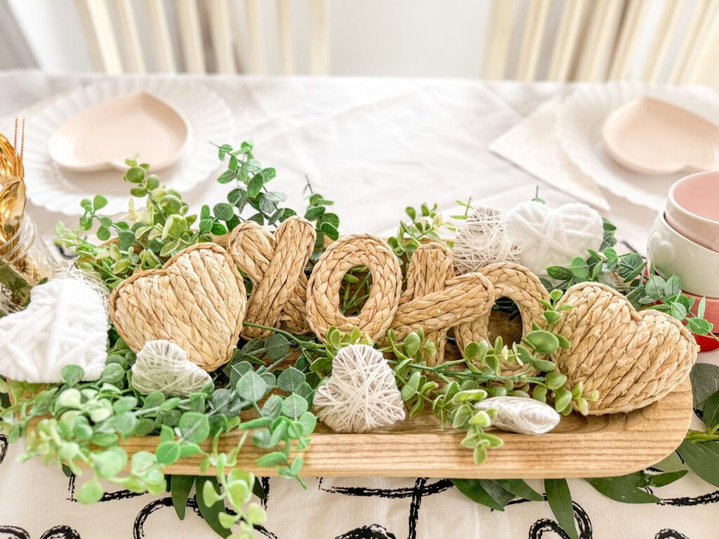 xoxo dough bowl on valentine table with subtle neutral decor of white yarn herats