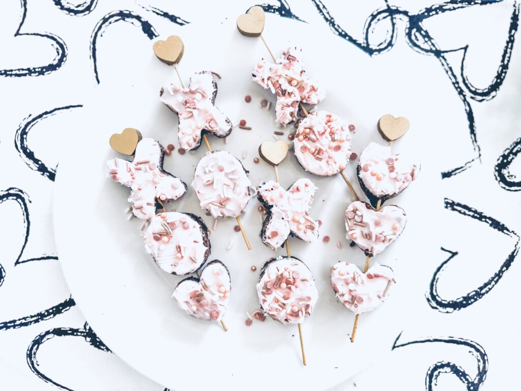 valentine brownie kabobs on skewers with pink icing and sprinkles