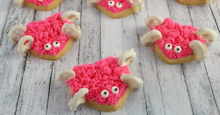 Colorful crab-shaped sugar cookies decorated with pink icing, white chocolate claws, and googly eyes, perfect for ocean-themed parties, kids' birthdays, or fun baking projects.