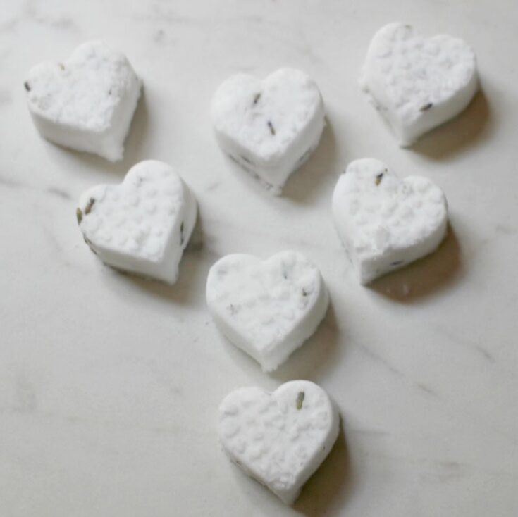 Heart-shaped white soap bars with chocolate specks on a marble surface, ideal for Valentine's Day or romantic gift ideas.