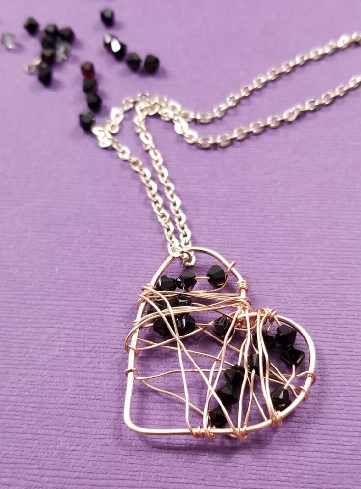 Delicate wire-wrapped heart pendant with black beads on a silver chain, perfect for Valentine's Day jewelry or gift-giving, showcasing elegant and unique handcrafted jewelry from A Hundred Affections.