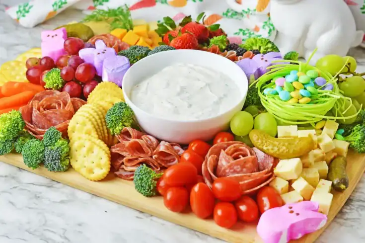 Colorful charcuterie board featuring fresh vegetables, fruits, cheeses, and festive Easter candy, perfect for spring celebrations and gatherings. Ideal for entertaining with a vibrant, appetizing presentation.