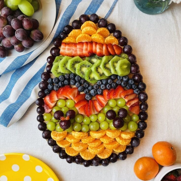 Colorful fruit platter decorated as a rainbow with strawberries, kiwi, blueberries, grapes, and mandarin oranges for a vibrant, healthy snack. Perfect for summer gatherings or celebrations.