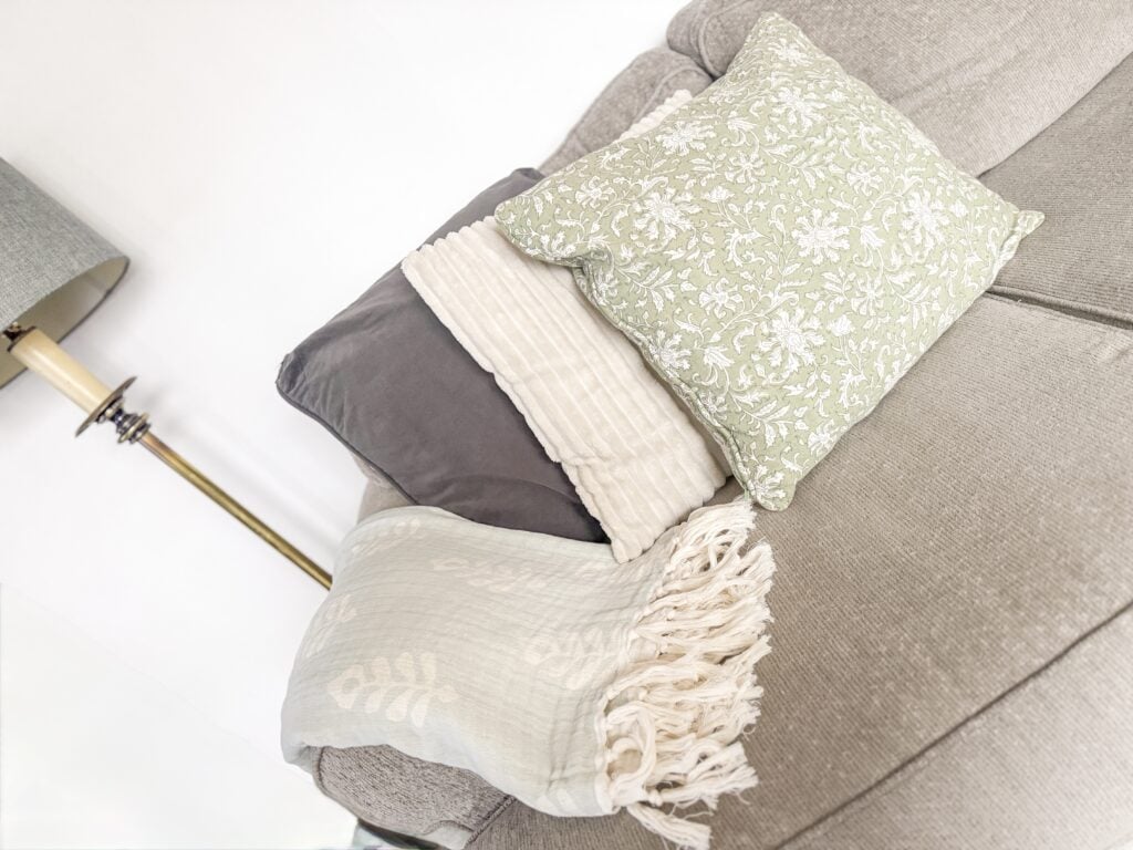 floral pillows and lightweight blanket on couch for vintage spring home