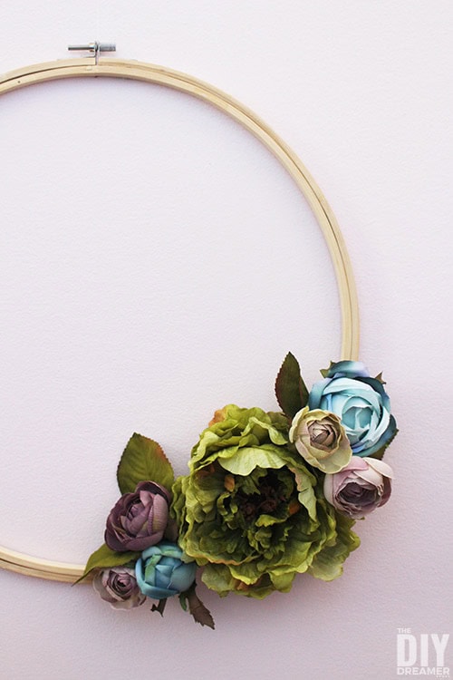Vintage floral embroidery hoop wall decor with pastel-colored roses and greenery for shabby chic or rustic home accents.