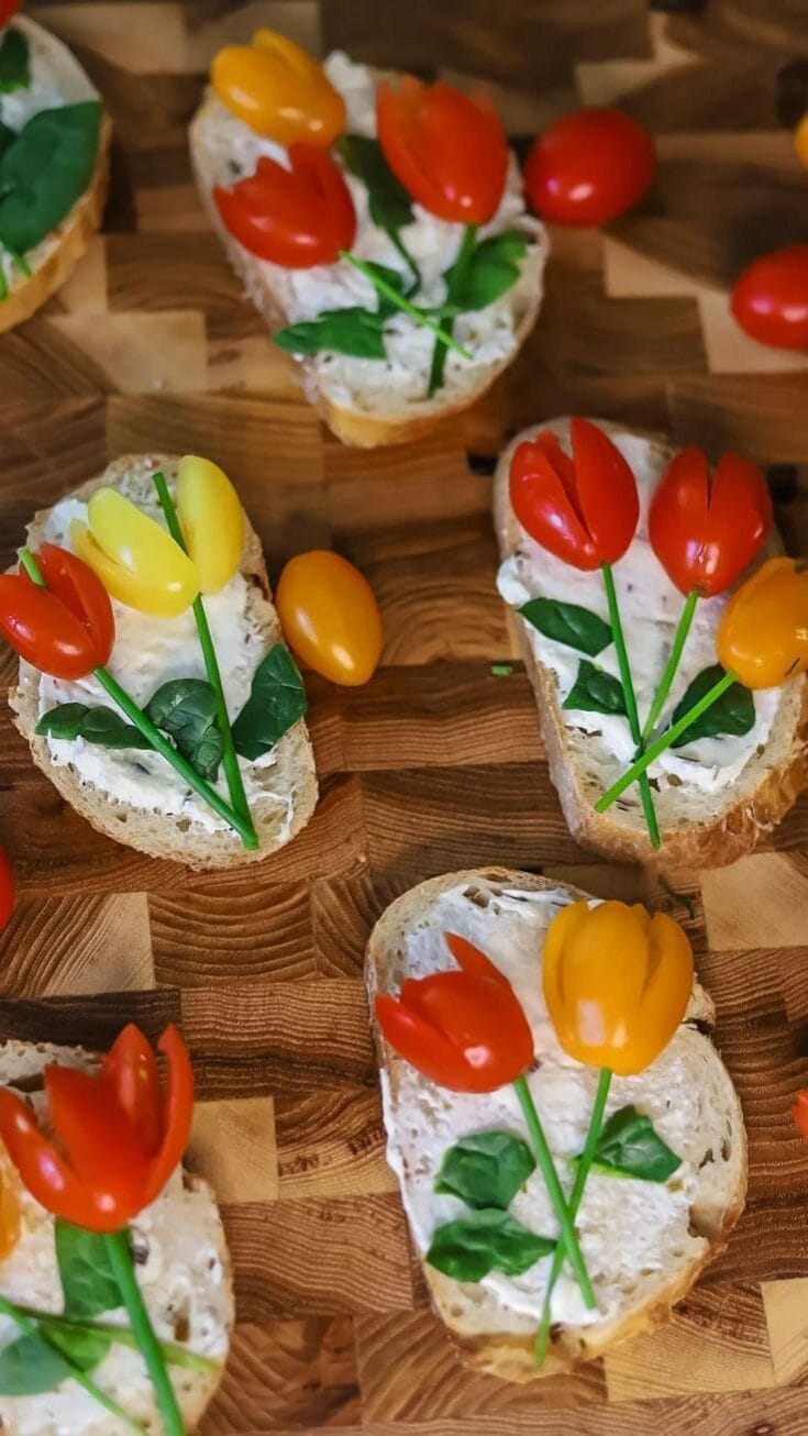 Colorful cherry tomato and basil appetizer bites on toasted bread with creamy spread, perfect for summer parties or casual gatherings.
