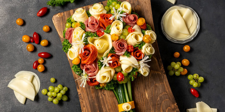 Fresh vegetable bouquet with cheese roses, grapes, and cherry tomatoes, on a dark background. Perfect for curated edible arrangements and gourmet grazing platters at special occasions.