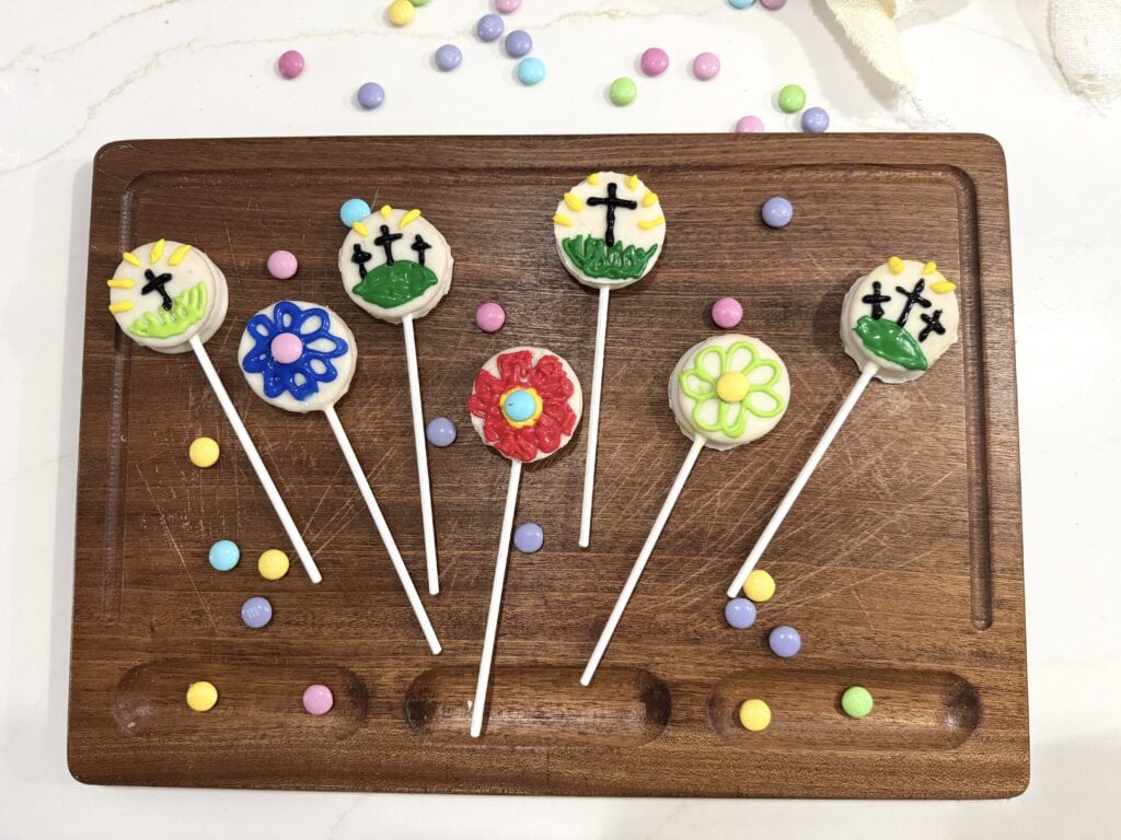 oreo easter pops on cutting board with crosses and flowers