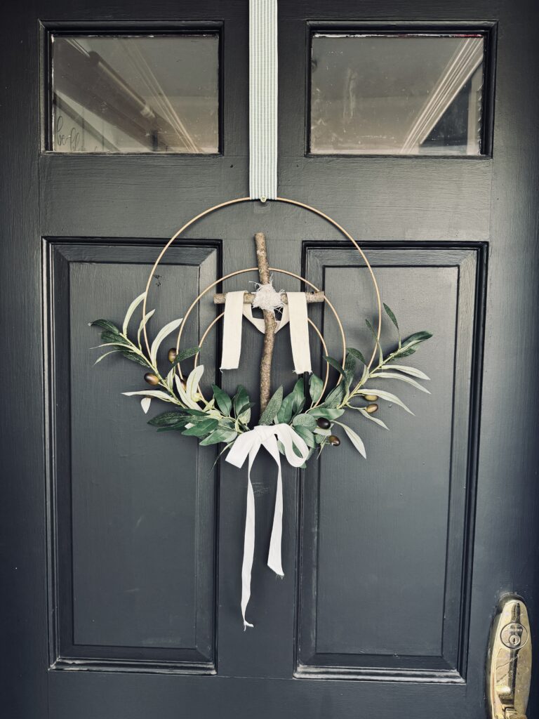 ribbon on top of easter cross wreath hanging on door