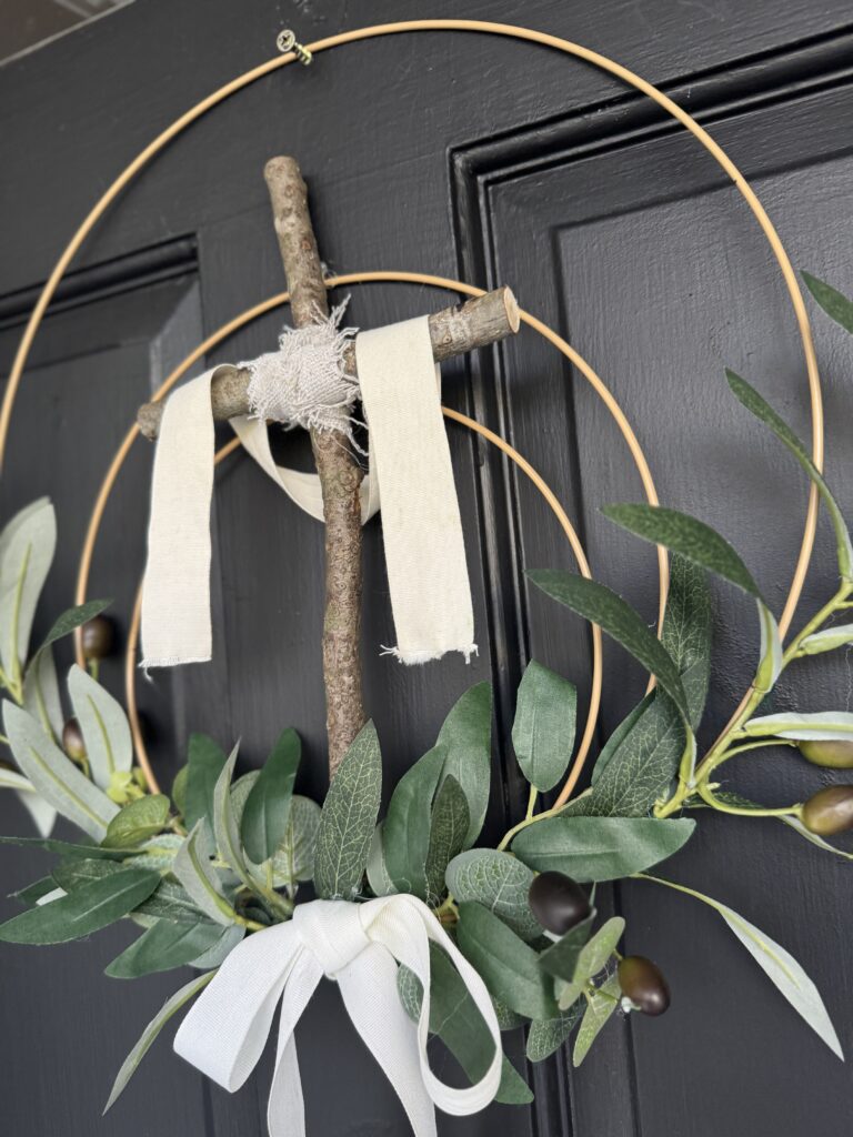 close up easter cross wreath with olive branches and ribbon bow