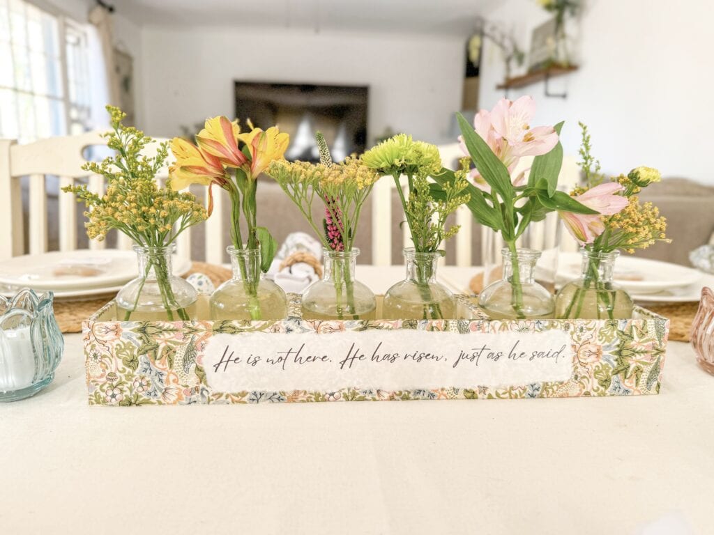 he is risen centerpiece on dining table with flowers for christian easter decor