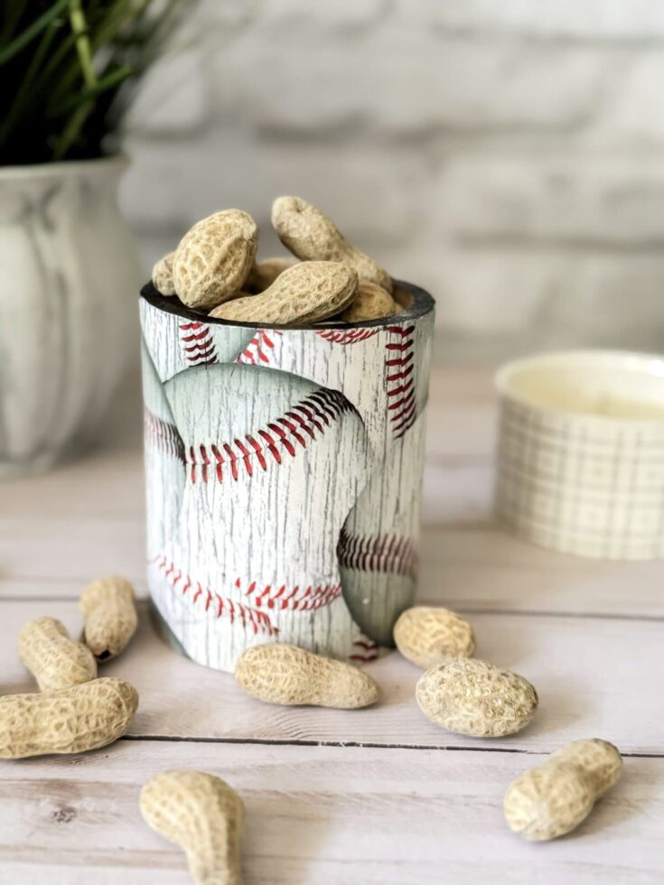 Peanuts in a baseball-themed container with a wooden background, emphasizing rustic and sports-inspired decor for a cozy, casual vibe.