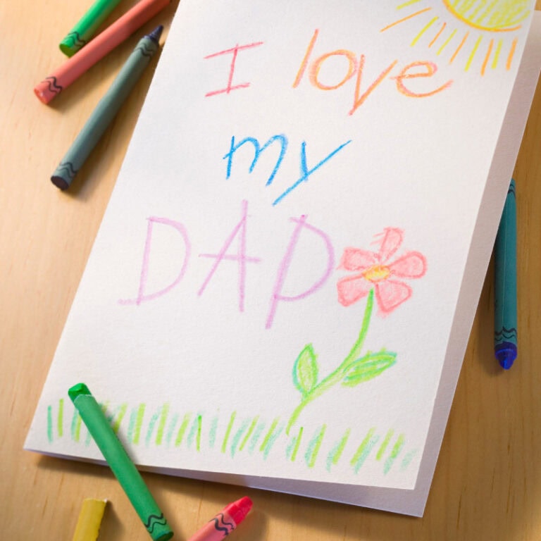 Heartfelt children's drawing of "I love my Dad" with colorful crayons and a flower, celebrating Father's Day with bright, cheerful artwork, perfect for heartfelt family expressions and dad appreciation.