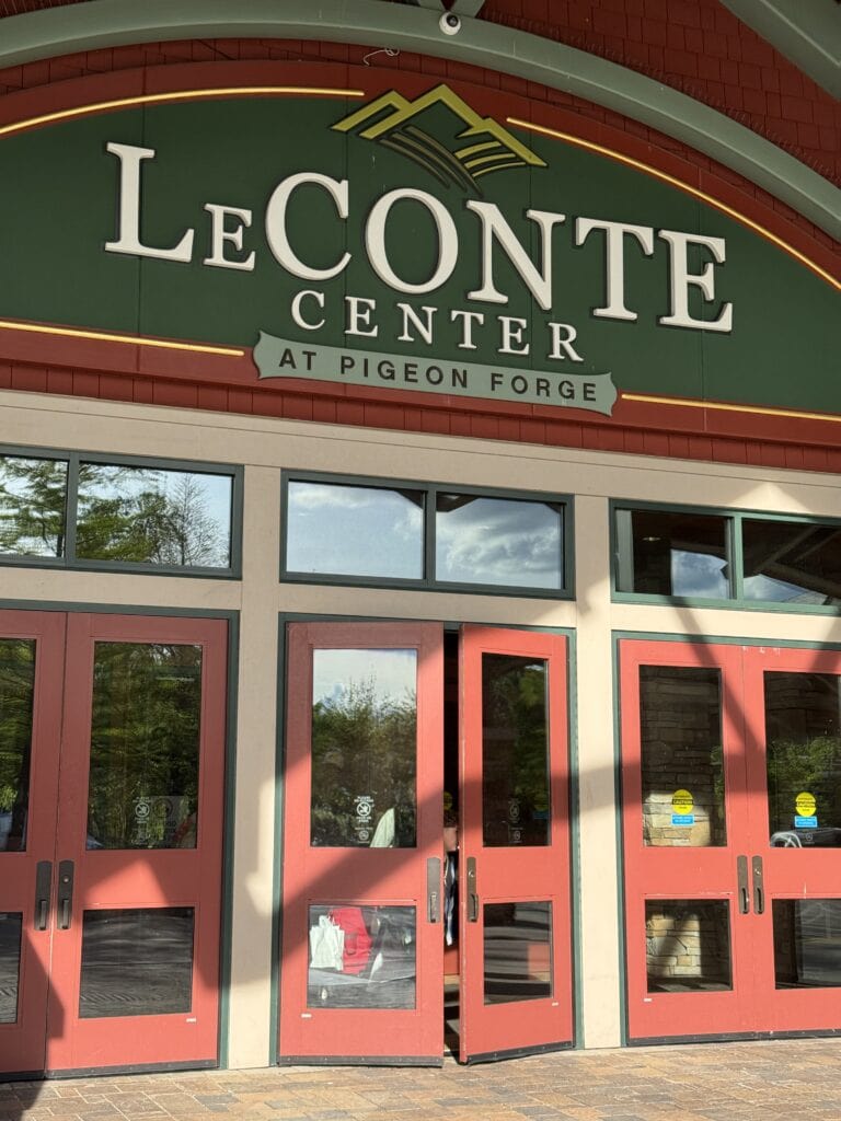 Le Conte Center at Pigeon Forge entrance with vibrant red double doors, located within the scenic Smoky Mountains, offering shopping, dining, and entertainment experiences.