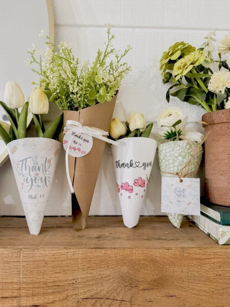 Colorful thank you flower bouquets with white tulips and green foliage, decorated with thank you tags, arranged on a rustic wooden surface for expressions of gratitude and appreciation.
