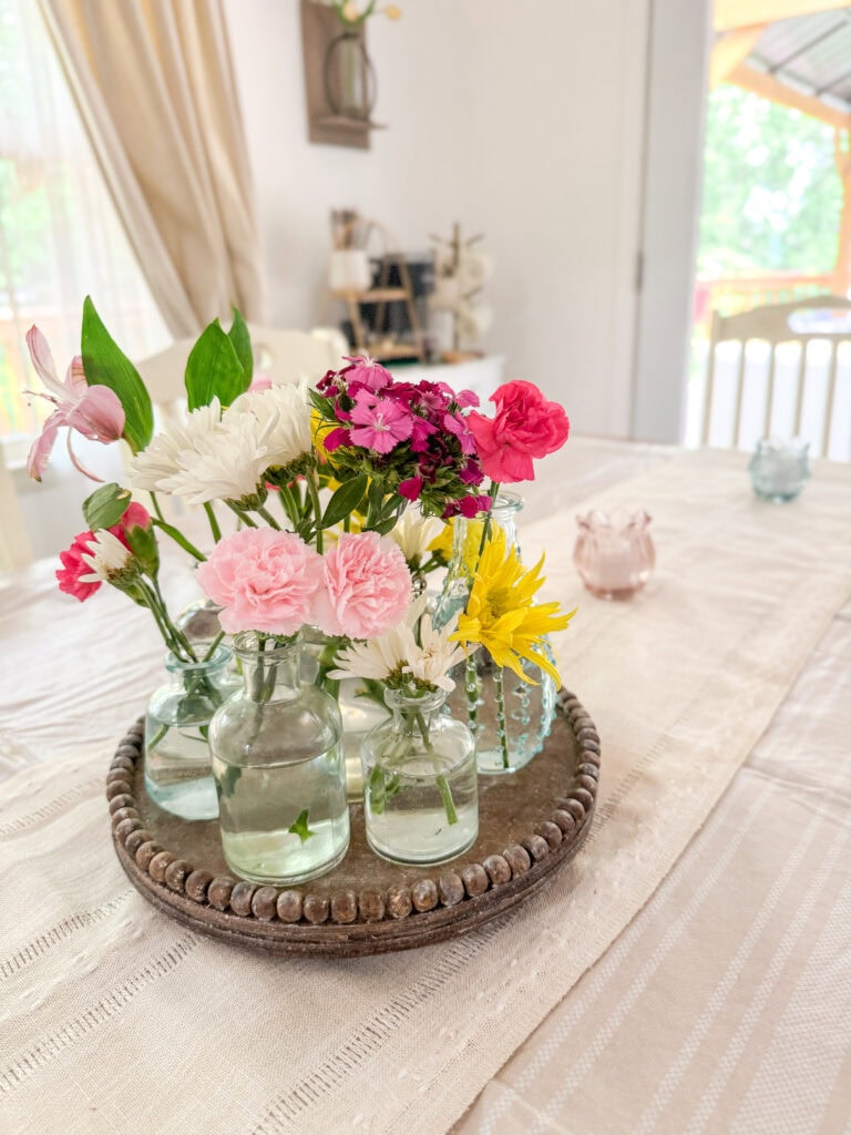 centerpiece with small blooms and votives on table