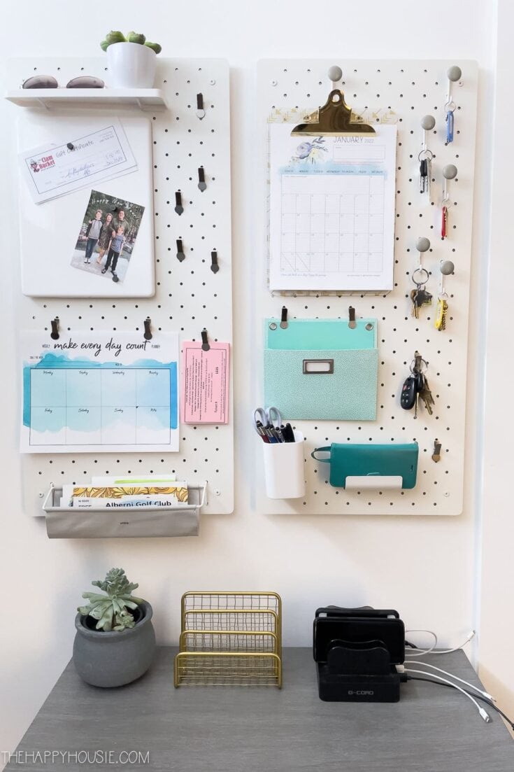 Organized white pegboard with office supplies, keys, and a calendar, perfect for home organization and productivity.