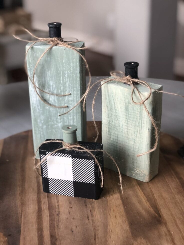 Handmade distressed wooden decorative bottles with black and white geometric patterned soap dispensers, tied with rustic twine on a wooden surface, ideal for farmhouse-inspired home decor.