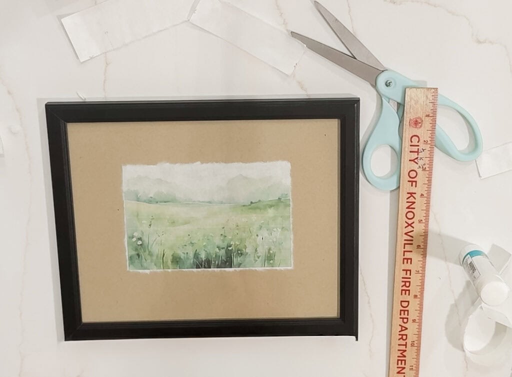 Delicate watercolor landscape painting with lush green fields and subtle sky hues, framed for wall decor, showcasing handmade art from A Hundred Affections.