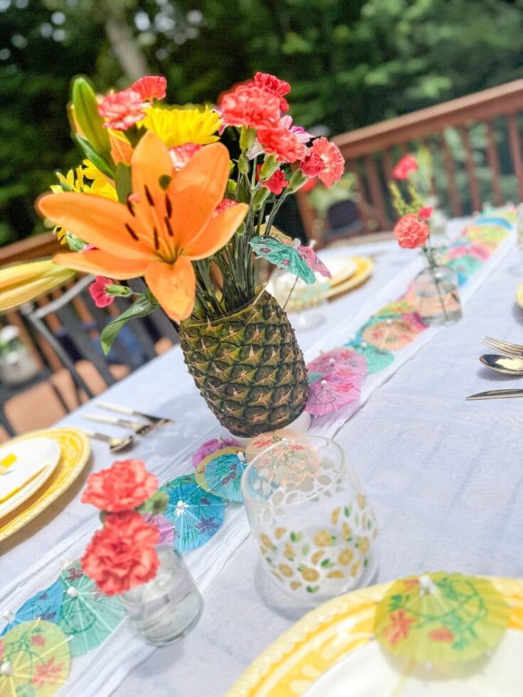 Colorful floral centerpiece in a pineapple vase for a summer outdoor party or brunch.