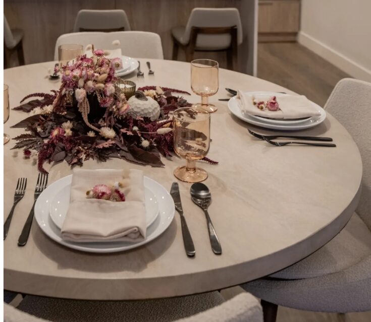 Delicate table setting with floral centerpiece at A Hundred Affections event, featuring elegant pink and white blooms, glassware, and sophisticated tableware for special occasions.