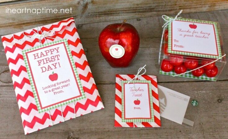 HAPPY FIRST DAY! Teacher appreciation gifts with red apple design, including treat boxes and gift tags for celebrating teachers, perfect for back-to-school or teacher appreciation events.