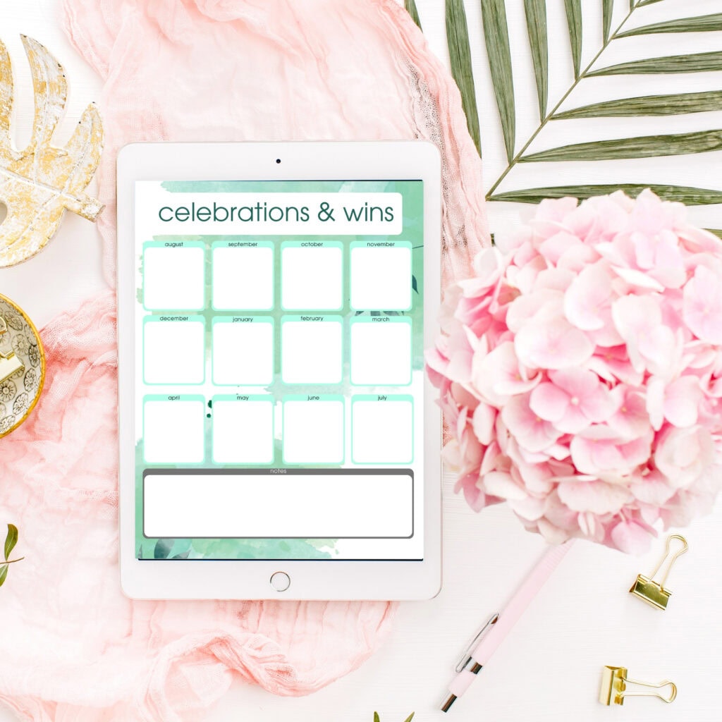 Celebrations and wins calendar on an iPad with floral and elegant workspace decor for organizing special moments and achievements.