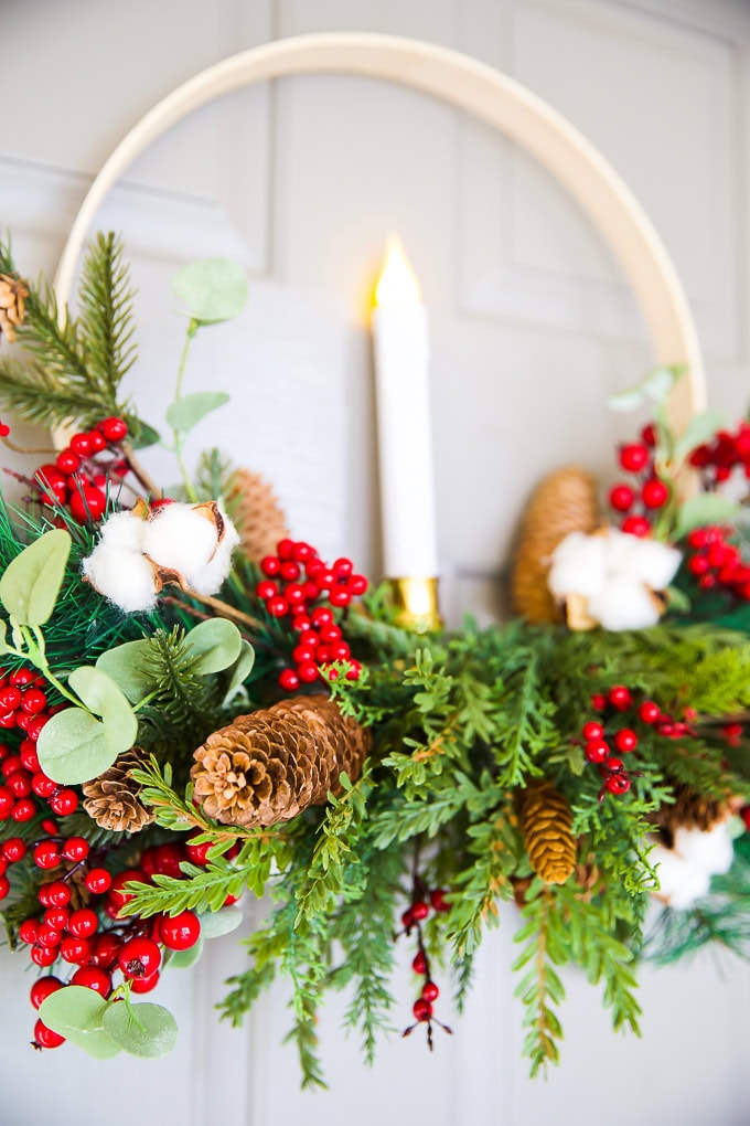 Vibrant Christmas greenery with pinecones, red berries, cotton branches, and eucalyptus, perfect for holiday decor or wreath crafts. Beautiful festive arrangement from A Hundred Affections.