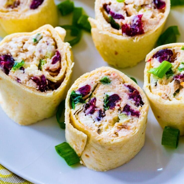 Cream cheese and blueberry breakfast burritos with chopped green onions on a white plate, perfect for healthy morning meals.