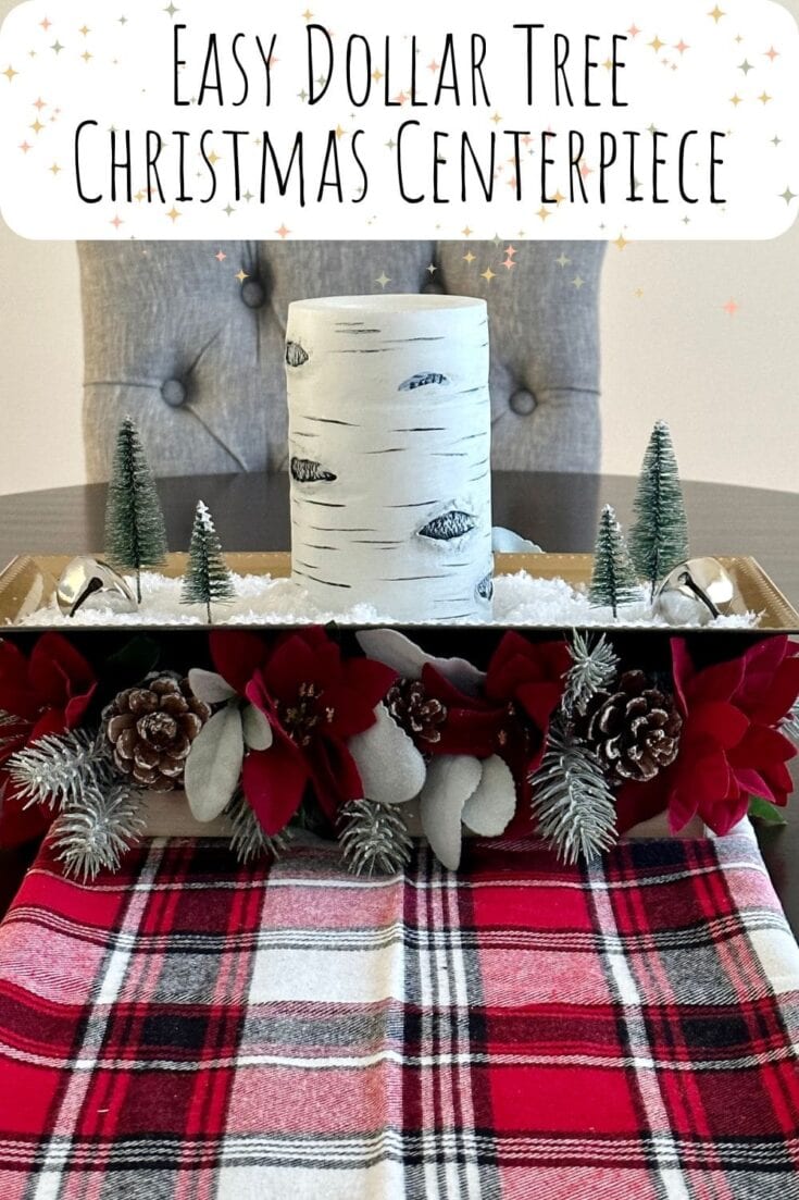 Rustic Christmas centerpiece with a faux birch tree candle, mini pine trees, pine cones, red poinsettias, and holiday foliage on a plaid table runner for cozy holiday decor.