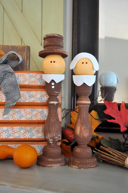Whimsical wooden figurines inspired by Mr. and Mrs. Christmas, perfect for fall or holiday decor, displayed on a rustic shelf with autumn leaves and cozy accents for a charming seasonal touch.
