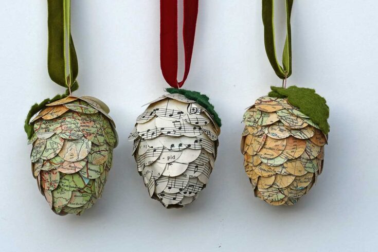 Handmade pinecone ornaments crafted from vintage maps and sheet music, perfect for autumn or holiday decor, emphasizing unique craft ideas from A Hundred Affections.