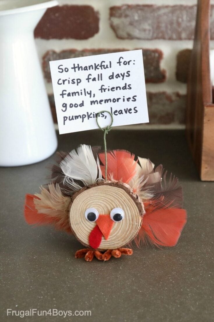 Colorful Thanksgiving turkey decoration made from a wood slice, feathers, googly eyes, a felt beak and wattle, with a handwritten gratitude note. Perfect for fall home décor and classroom projects.