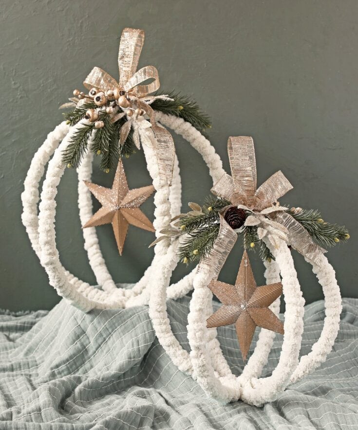 Rustic Christmas holiday decor with white fluffy ornaments, natural pinecones, greenery, and metallic star and ribbon accents, perfect for festive home decorations.