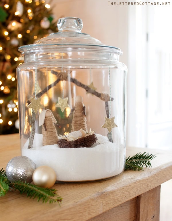 Mini nativity scene inside a glass jar with snow, stars, and twigs for Christmas decor. Perfect for holiday home decorations and creating a cozy festive atmosphere.