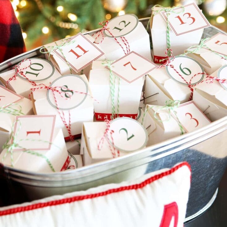 Advent calendar with numbered white paper boxes tied with red and green string, colorful Christmas background.