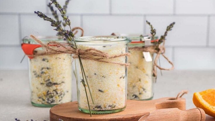 Lavender-infused homemade bath salts in glass jars with rustic twine and lavender sprigs, perfect for relaxing spas and self-care routines.