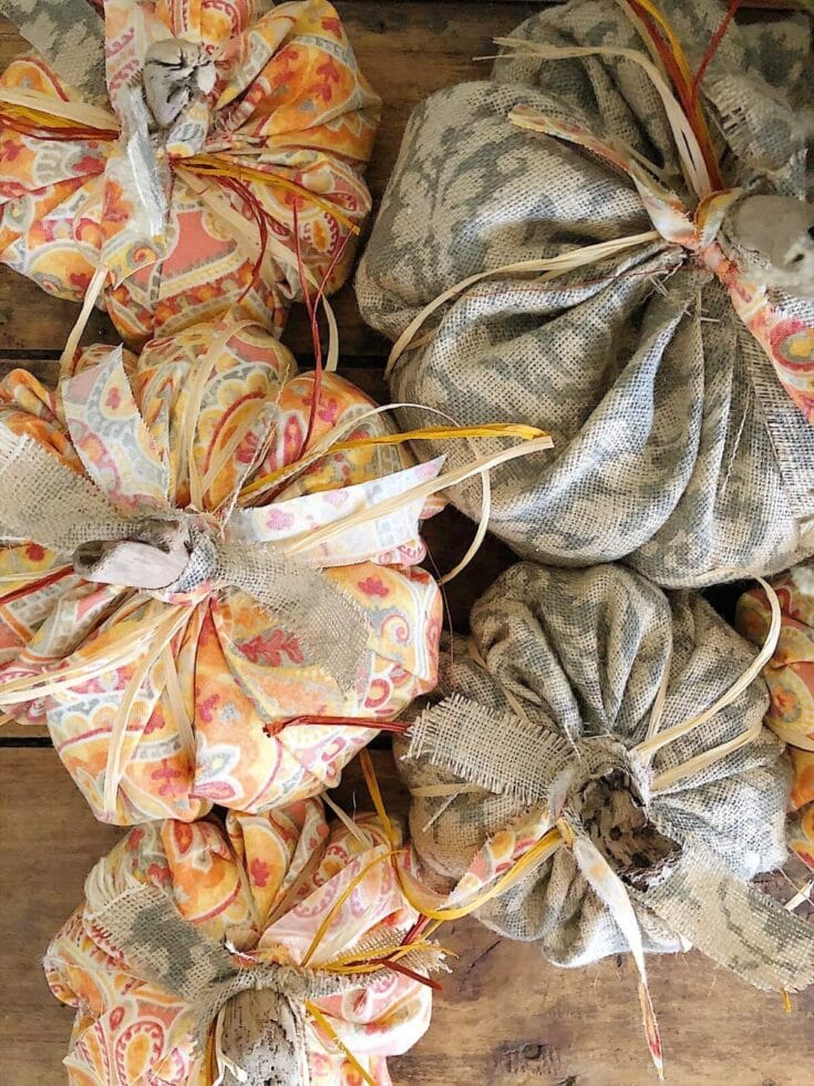 Colorful fabric gift bundles tied with raffia and ribbon, handcrafted with patterned textiles, perfect for gift wrapping or decorative purposes.