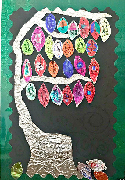 Colorful paper leaves with words like "Kindness," "Hope," and "Love" on a black background, showcasing a creative and heartfelt school project about positive traits and community values.