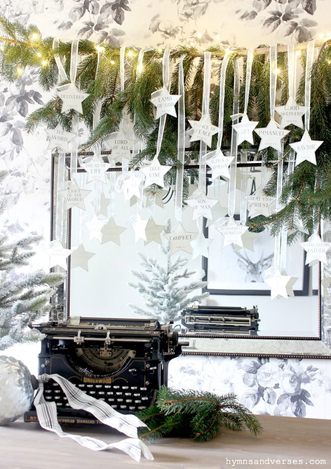 Deliverer, lamb of God, good shepherd, Lord of all, face of peace, the word, bride of life, true vine, Alpha & Omega, son of man, great high priest, prophet, counselor, Savior, light of the world, wreath of Christmas lights, festive holiday decor, vintage typewriter, holiday inspiration, Christmas tree decorations, spiritual Advent decor, seasonal home decor, meaningful Christmas display, festive religious decorations.