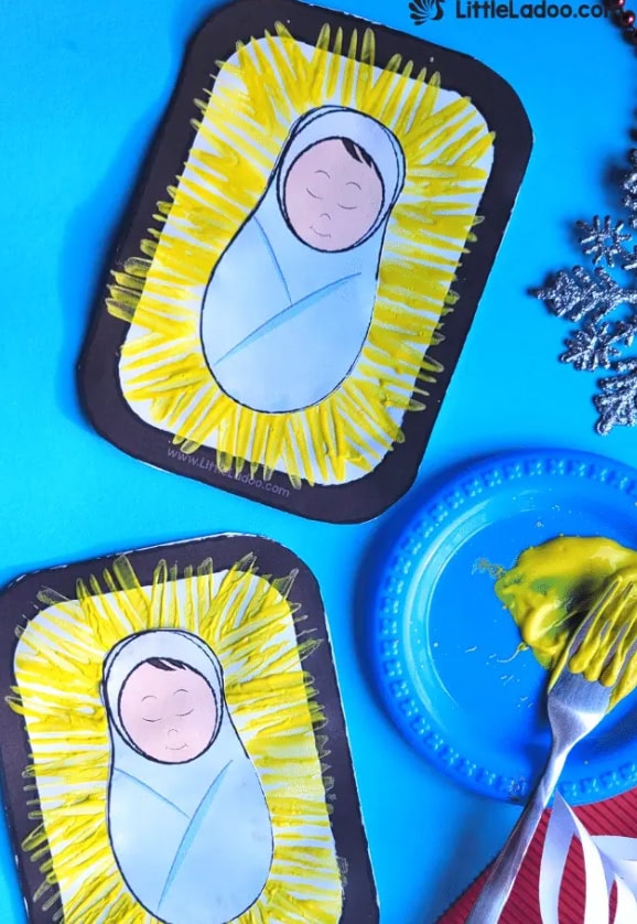 A beautiful nativity craft featuring a baby Jesus illustration with yellow radiating lines on black-bordered paper, perfect for Christmas religious activities.