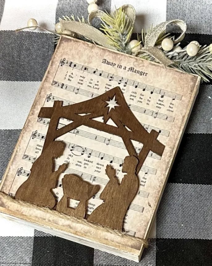 Handcrafted wooden nativity scene on vintage sheet music, perfect Christmas decor, blending rustic charm and musical nostalgia for festive home decoration.