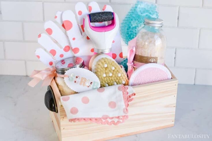 Soft pink and white bath and skincare gift set in a wooden box, featuring textured scrubbing tools, plush towels, and relaxing bath salts, perfect for self-care and pampering routines.